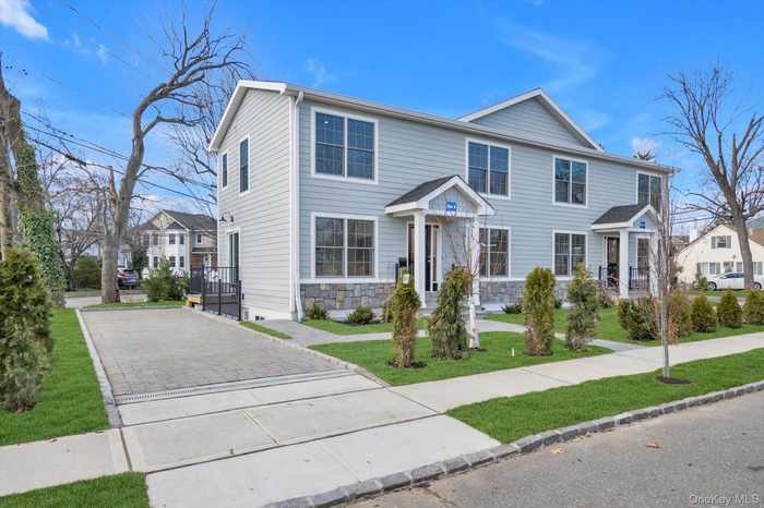 View of front of home featuring a front yard and stone siding