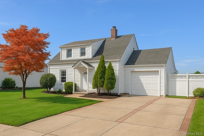 View of front of house featuring an attached garage, concrete driveway, a chimney, and a shingled roof