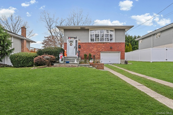 View of front facade with brick siding, an attached garage, and driveway