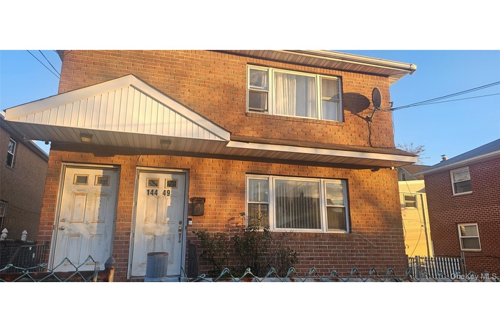 View of front of house featuring brick siding and a porch