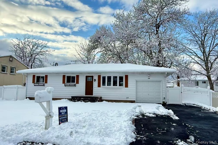 Ranch-style house with a garage, driveway, and a gate