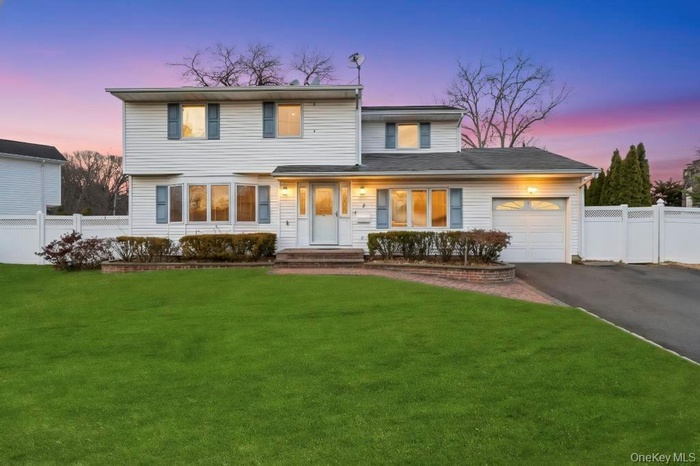 Traditional home featuring asphalt driveway and an attached garage