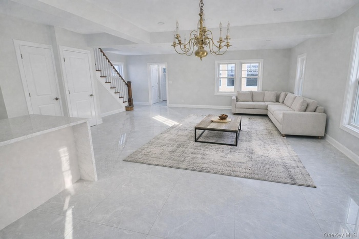 Living room Staged featuring stairway and a chandelier