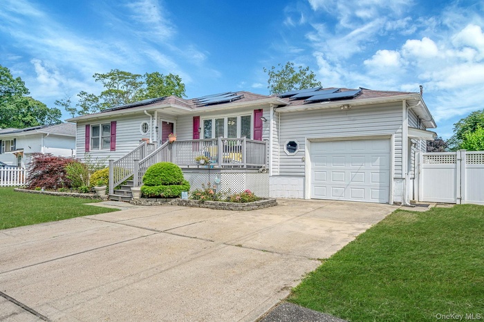Ranch-style house featuring concrete driveway, a garage, roof mounted solar panels, and a porch
