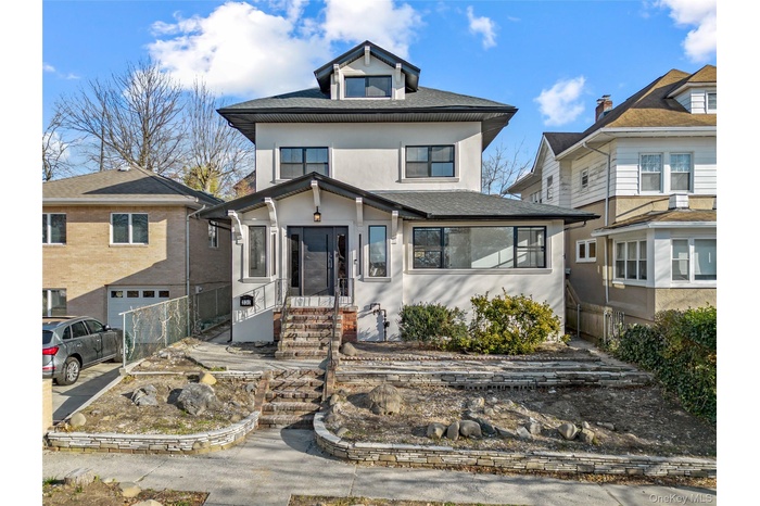 Traditional style home featuring stucco siding, roof with shingles, and a sunroom