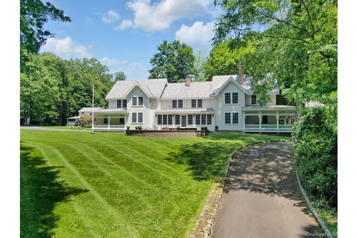 Rear view of house featuring a chimney and a yard