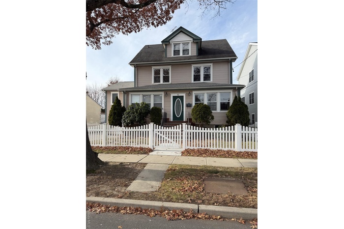 American foursquare style home with a fenced front yard