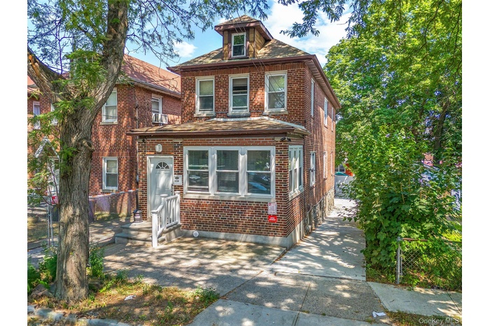 American foursquare style home featuring brick siding