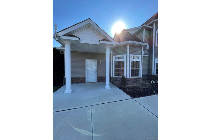 Entrance to property featuring stone siding and covered porch