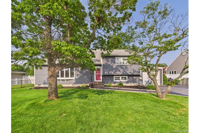 Tri-level home featuring a garage, driveway, and a shingled roof