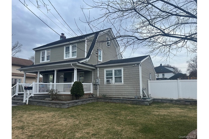 Colonial inspired home with a gambrel roof, a porch, and a chimney