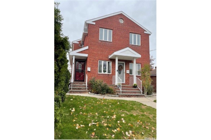 View of front of home featuring a front yard and brick siding