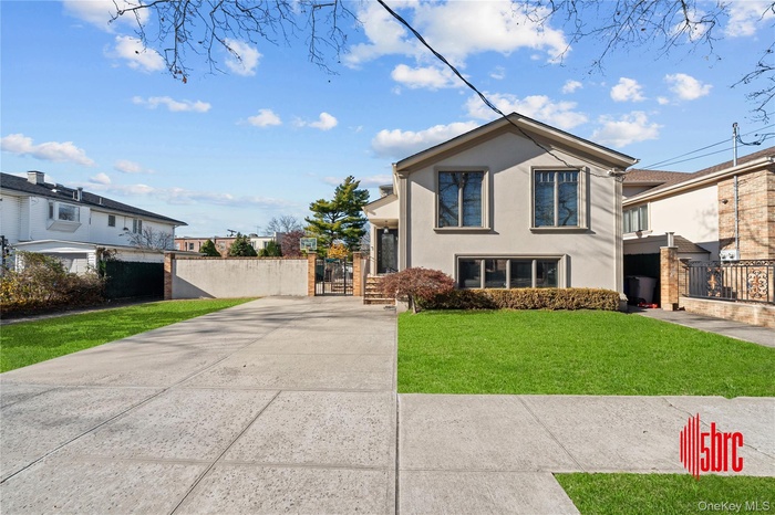 View of front facade featuring stucco siding and a gate
