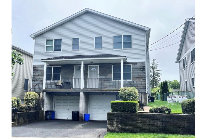 View of front of house with a garage and asphalt driveway