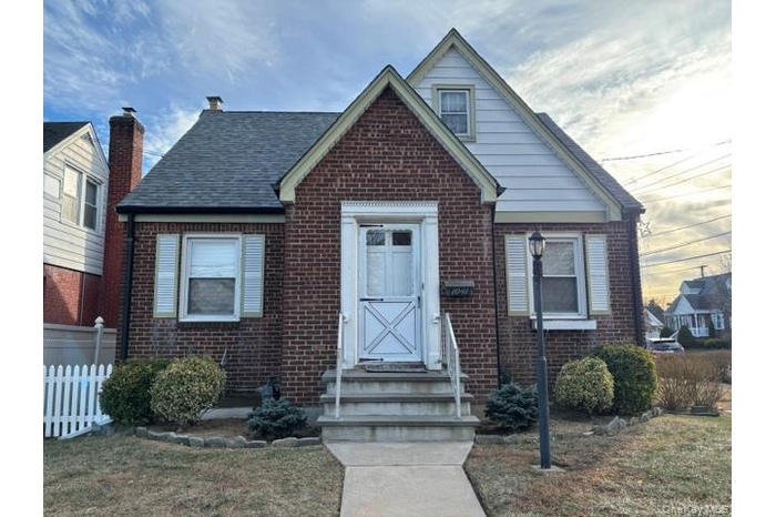 Bungalow-style house featuring brick siding and roof with shingles