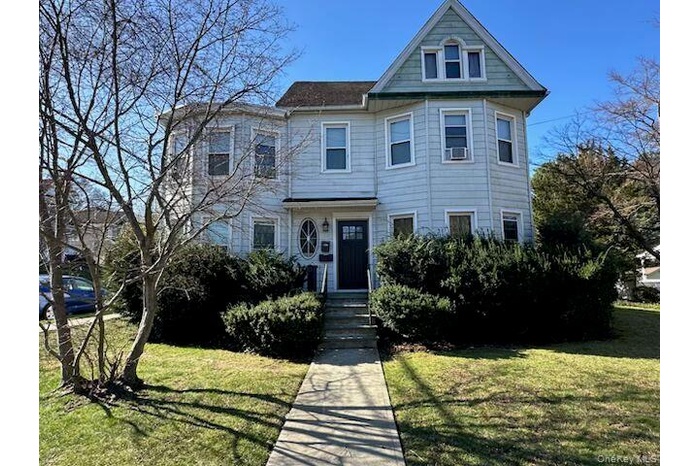 Victorian-style house with a front lawn