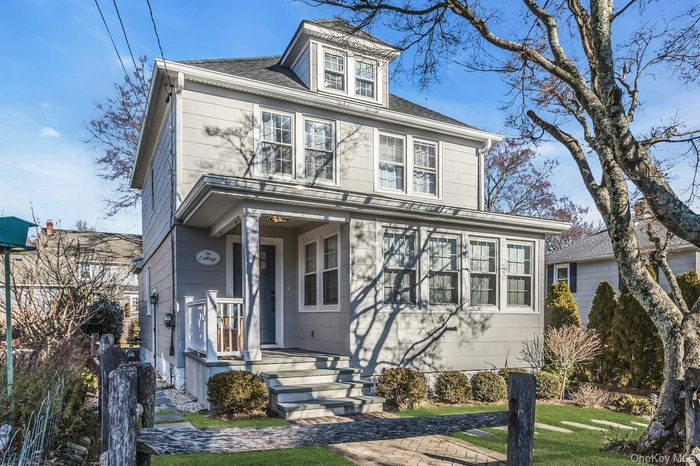 Traditional style home featuring a front lawn and a shingled roof