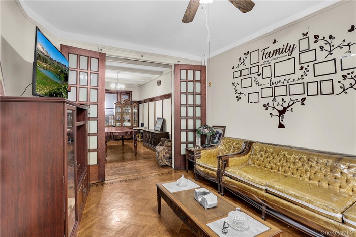 Living room featuring a chandelier, french doors, and ceiling fan
