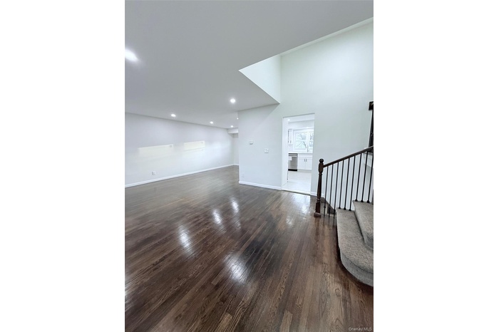Unfurnished living room with stairway and dark wood finished floors
