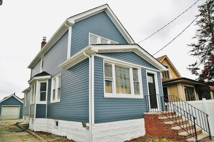 View of home's exterior with a garage, a chimney, and an outdoor structure