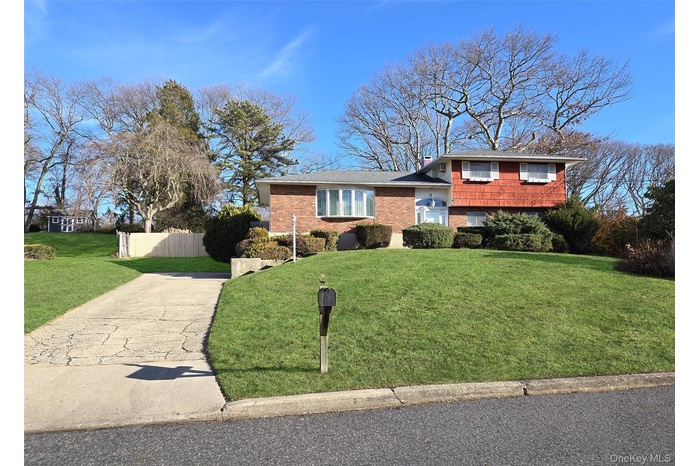 Split level home featuring brick siding and concrete driveway