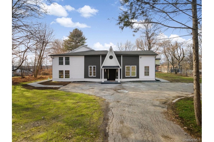 View of front facade featuring asphalt driveway and a shingled roof