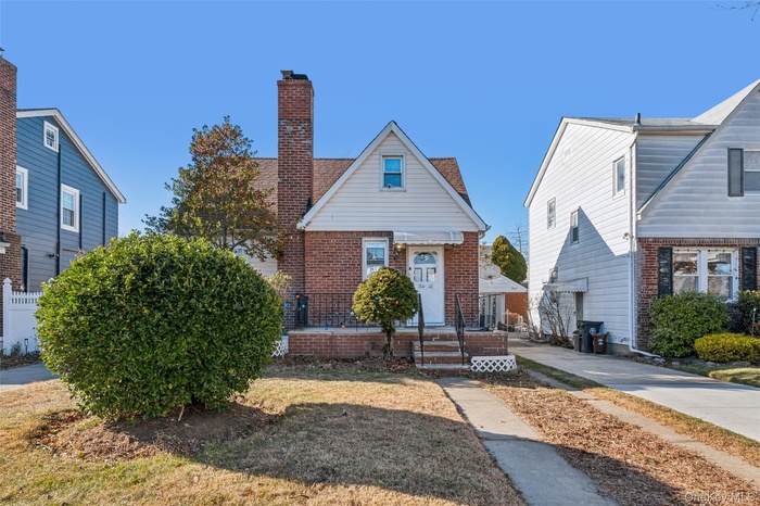 Bungalow with brick siding and a chimney