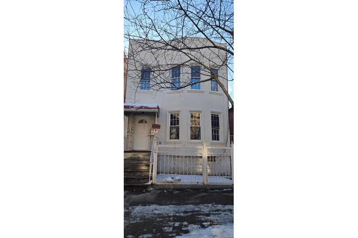 View of home's exterior featuring a fenced front yard, stucco siding, and a gate