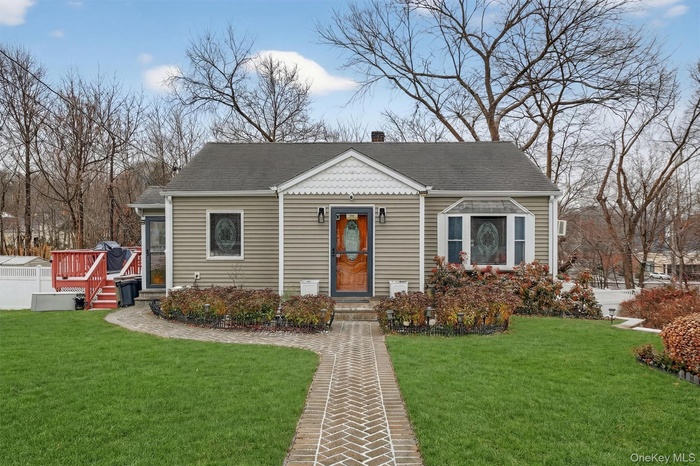 Bungalow featuring a front lawn, roof with shingles, and a chimney