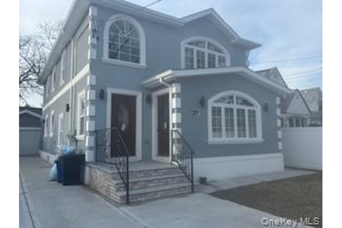 View of front of house featuring an outdoor structure, stucco siding, a detached garage, and concrete driveway