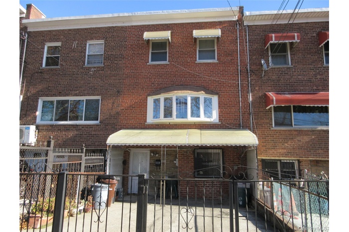 Traditional-style home featuring a fenced front yard, brick siding, and a gate