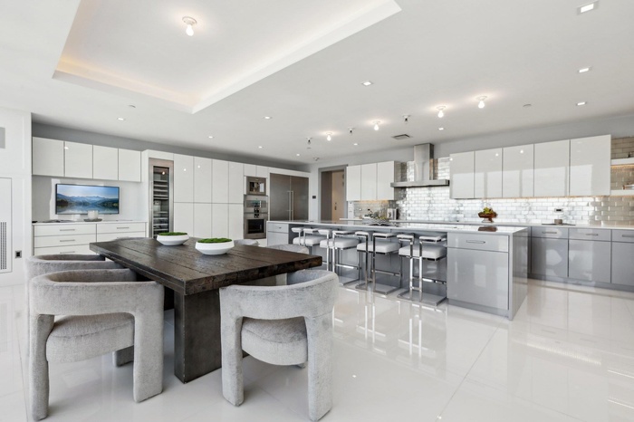 Dining room with light tile patterned floors, a raised ceiling, and recessed lighting