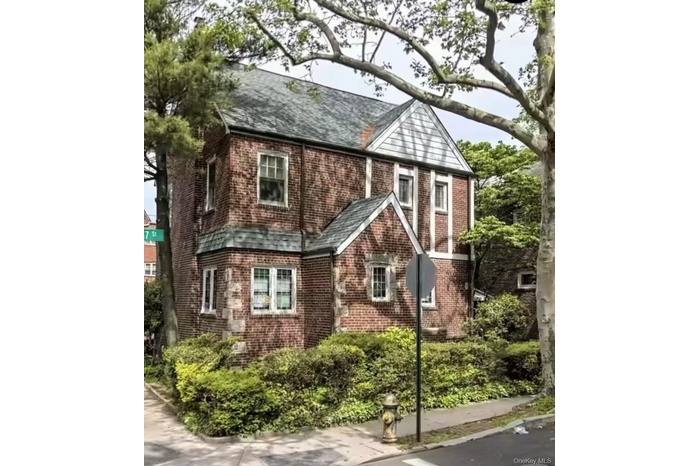 Tudor home with a shingled roof and brick siding