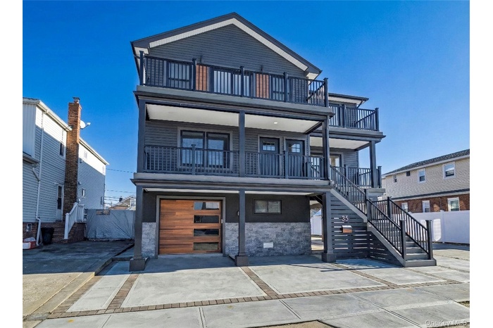Contemporary house featuring stairs, driveway, a porch, and a garage