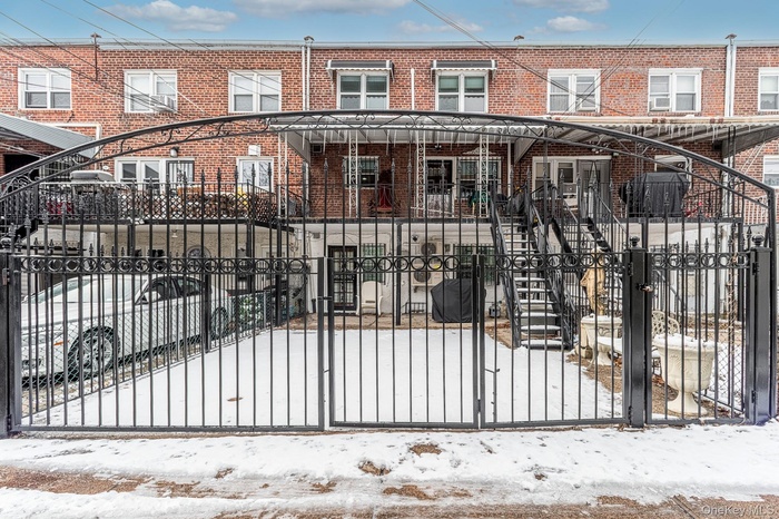 Gate with a fenced front yard, stairway, and covered porch