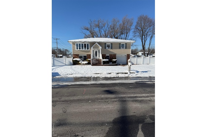 Split foyer home featuring brick siding and a garage