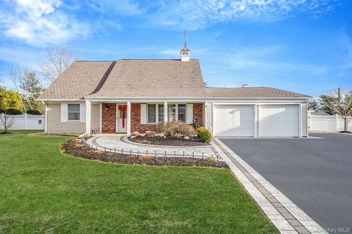 View of front of house with a porch, asphalt driveway, an attached garage, and a shingled roof