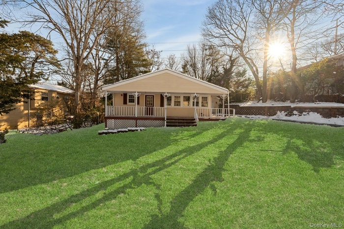 View of front of property featuring covered porch and a front lawn