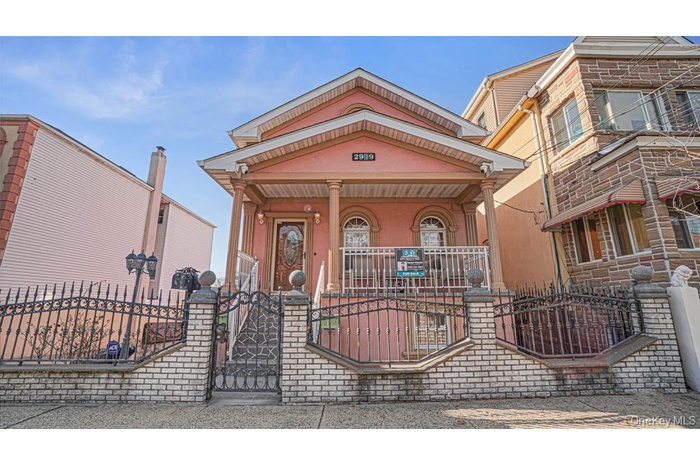 View of front facade with covered porch, a fenced front yard, a gate, and stucco siding