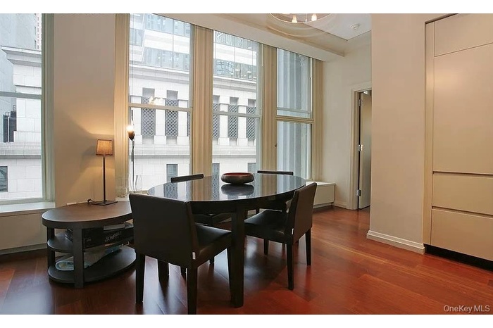 Dining area featuring dark wood-style flooring and baseboards
