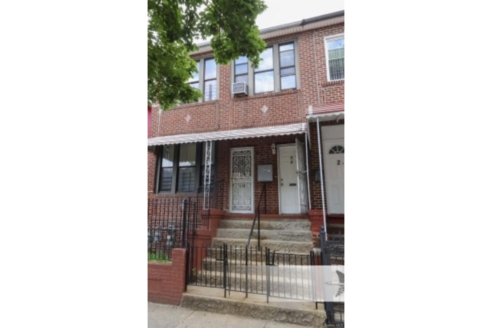 Traditional home featuring a fenced front yard, brick siding, and covered porch