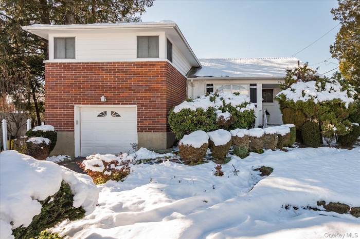 View of front of house with brick siding and a garage
