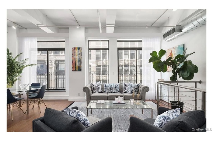 Living area with wood finished floors and a wall mounted air conditioner
