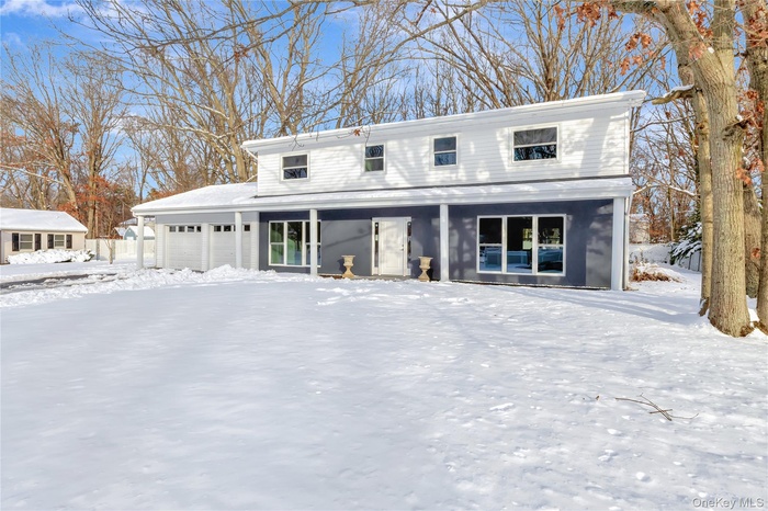 Traditional-style house featuring a garage and covered porch