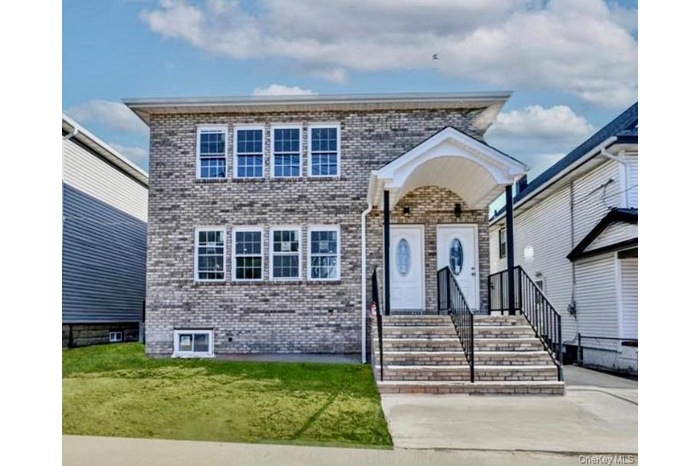 View of front of home with brick siding and a front yard