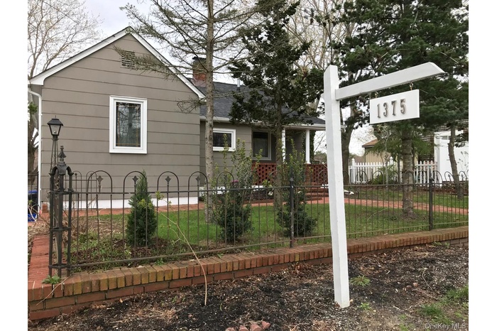 View of front of house featuring a fenced front yard and a shingled roof