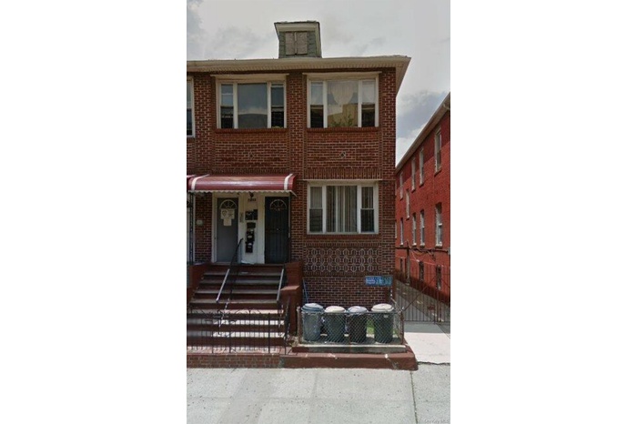 View of front of home with brick siding, a porch, and a fenced front yard