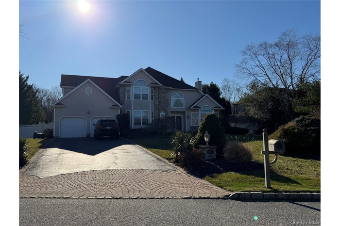 View of front of property with driveway, a front lawn, and a garage