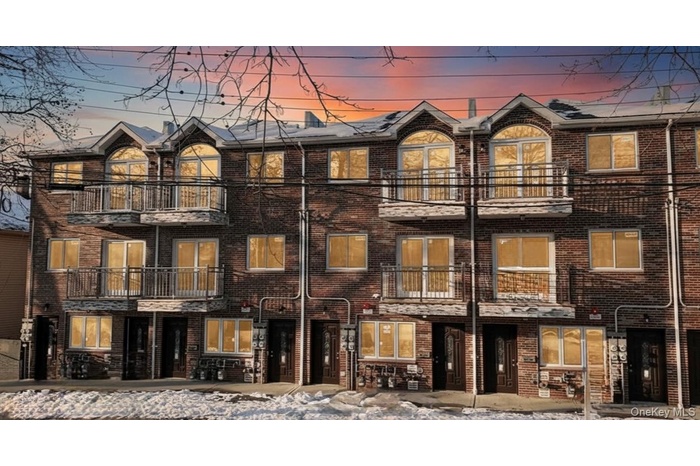 View of front facade featuring a balcony and brick siding