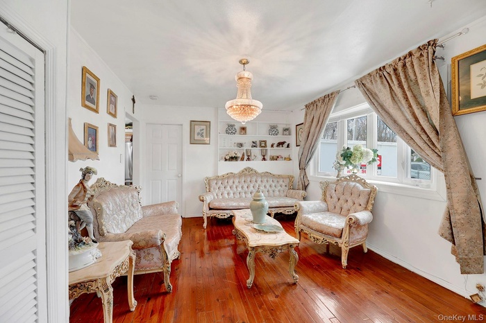 Sitting room featuring wood-type flooring and a chandelier